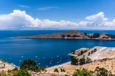 Titicaca Gölü 'nün Sakin Sahnesi Resimli Dağ Arkaplanı ile Isla del Sol' dan Ele Geçirilen Suyun Üzerinde Renkli Teknelerle