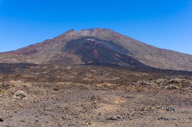 Teide Dağı 'nın eskimiş patlamalardan ve İspanya' nın Tenerife Ulusal Parkı 'ndaki engebeli lav sahasından koyu katılaşmış lavlarla çevrili dramatik manzarası.