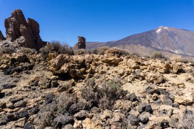Iconic Roques De Garcia ve engebeli volkanik arazi ve Teide Ulusal Parkı Tenerife Kanarya Adaları 'nın gökteki mavi gökyüzü çerçeveli Teide Yanardağı