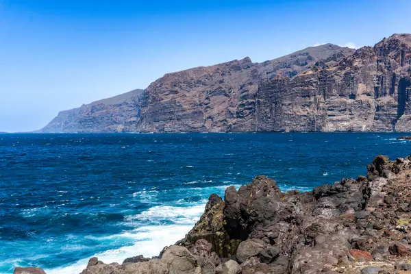 Güneşli bir günde Tenerife Adası 'ndaki Atlantik Okyanusu' ndan yükselen Los Gigantes uçurumlarının manzarası