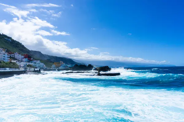Kuzey Tenerife 'deki El Pris' in doğal kaya havuzlarını kaplayan dalgalı deniz köpüklü dalgaları ve kanarya adalarındaki engebeli volkanik kıyı şeridini kaplıyor.