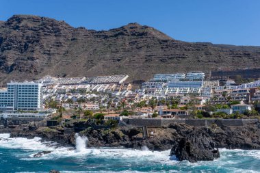 İspanya 'nın Tenerife kentinde bulunan Los Gigantes' in Şehir Panoramik Manzarası, Atlantik Okyanusu ve Volkanik Uçurumlarla Yüzleşen Uzun Turizm Binaları ve Otelleri