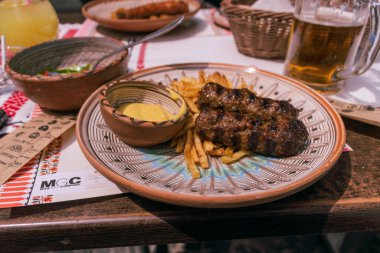 Mici ya da Mititei, Romanya 'nın geleneksel piknik yemekleri, çalıların arkasındaki ızgarada ya da uzun otlarda.