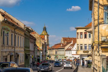 BRASOV, ROMANIA, Romanya 'nın Brasov kentindeki belediye binasının parlayan kulesiyle George Baritiu' nun sokak manzarası.