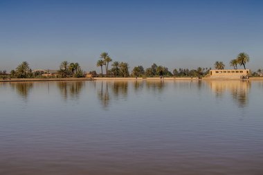 Menara bahçeleri, arka planda Atlas Dağları, Marakeş, Fas karlı havuz ve pavyonu yansıtıyor..