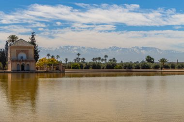Menara bahçeleri, arka planda Atlas Dağları, Marakeş, Fas karlı havuz ve pavyonu yansıtıyor..