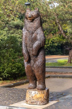 Plitvice Lakes Ulusal Parkı, Hırvatistan. Ormanlık bir parkta heykel üzerinde duran bir ayının bronz heykeli..