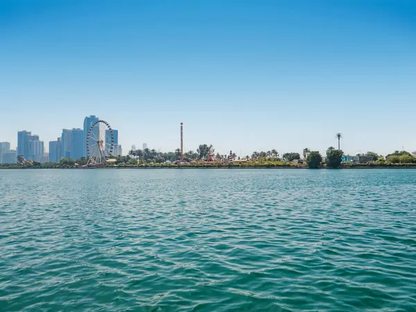 Al-Majaz 'ın göl kenarından, dönme dolabı ve yüksek binaları olan Al-Montazah Parkı' na bakın. BAE. Sharjah.
