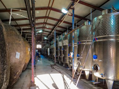 KVARELI, GEORGIA. Kindzmarauli Şirketi 'nin bahçesindeki şarap üretimi için fermantasyon tanklarının yanındaki işçiler