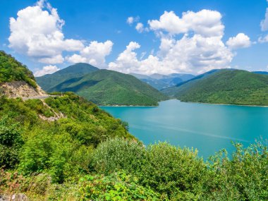 Gürcistan Askeri Yolu 'ndaki Kafkasya Dağları ile çevrili, turkuaz suyla çevrili Zhinvali Barajı Panoraması. Aragvi Nehri, Gürcistan 'da hidroelektrik baraj.