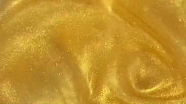 gold abstract liquid motion abstract background with copy space. Shine glitter fluid metallic yellow color paint. Texture abstract mica powder cloud swirling underwater.