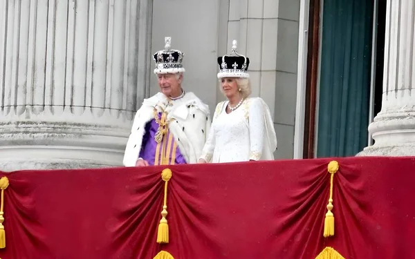ロンドン イギリス イギリス 2023年5月6日 戴冠式後 バッキンガム宮殿のバルコニーにはカレル3世とコンソート王妃のカミラが見られます チャールズ王女王カミラは王冠の宝石を身に着けて ロイヤリティフリーのストック写真