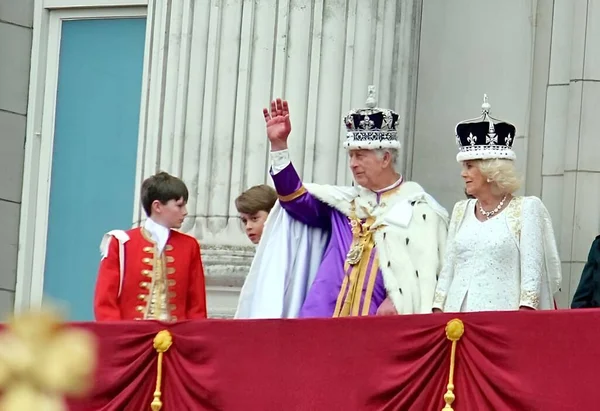 ロンドン イギリス イギリス 2023年5月6日 戴冠式後 バッキンガム宮殿のバルコニーにはカレル3世とコンソート王妃のカミラが見られます チャールズ王女王カミラは王冠の宝石を身に着けて ロイヤリティフリーのストック画像