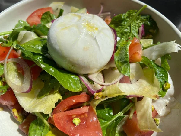 Domatesli salata ve Burrata peyniri, mozzarella ve fesleğen ve zeytinyağı arka planlı krema. 