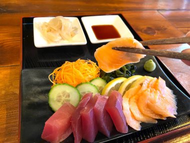 Japon yemekleri sashimi ton balığı somonu (çiğ dilimlenmiş balık, kabuklu deniz hayvanı) ve yosun havucu limonu ve wasabi.
