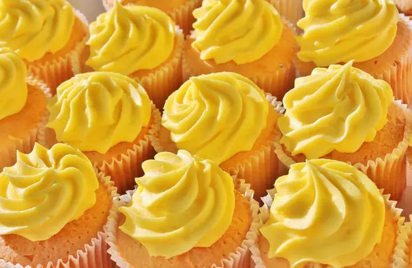 カップケーキは黄色のレモンの霜でハッピー誕生日お祝い渦巻き砂糖バター黄色のレモンアイシングの多くは ストックフォト ストックフォト画像画像 — ストック写真