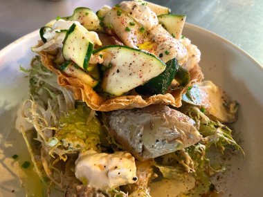 Stracciatella ve kabak turtası ve enginar salatalı vejetaryen yemeği.