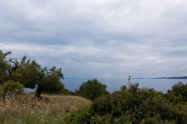 Sonbaharda bulutlu bir gökyüzünün altında, Yunanistan 'ın Chalkidiki kentindeki Toroni köyünün etrafındaki tepelerden deniz manzarası nefes kesici.
