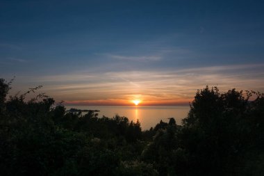 Yunanistan 'ın batı kesiminden denize doğru muhteşem bir gün batımı, Mathraki Adası.