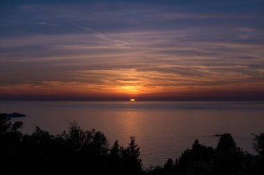Yunanistan 'ın batı kesiminden denize doğru muhteşem bir gün batımı, Mathraki Adası.