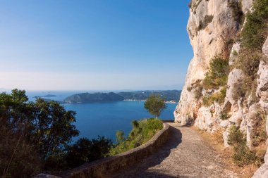 Ünlü eşek yolu ya da Yunanistan 'ın Korfu kentindeki Gaidouromonopati, deniz manzaralı bir uçurum üzerine inşa edilmiştir.