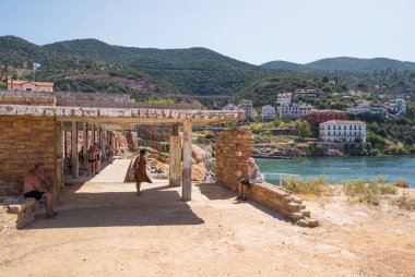 June 25th 2024 - Aidipsos, Greece - The waterfront of Aidipsos, a Greek town in North Evia famous for its hot springs and spas, with lots of people enjoying the free warm water spa clipart