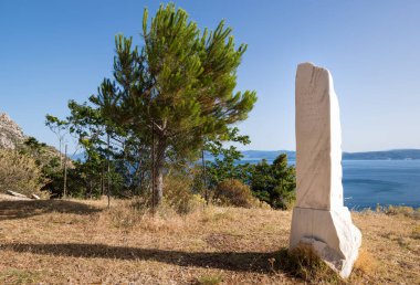 23 Haziran 2024 - Kuzey Evia, Yunanistan - Yunanistan 'ın kuzeyindeki Galataki manastırında, Yunanistan Cumhurbaşkanı' nın 2016 yılında diktiği çam ağacının yanında bir anıt 