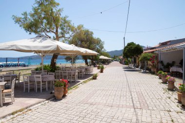 26 Haziran 2024 - Kuzey Evia, Yunanistan - Psaropouli plajında, tavernaları ve kafeteryaları olan bir cadde, Kuzey Evia, Yunanistan