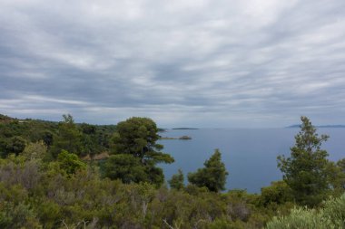Sithonia, Chalkidiki, Yunanistan 'da deniz kenarında bulutlu bir gökyüzü altında güzel bir manzara