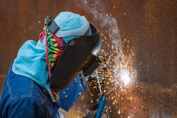 Male  worker wearing protective clothing and repair welding spark shell plate industrial construction oil and gas or  storage tank inside confined spaces.