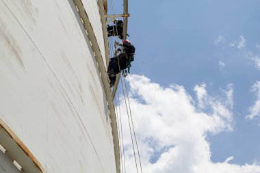 Üst görünüm erkek işçi aşağı yükseklik tankı halat erişim güvenlik denetimi Kalınlık depolama yağ ve benzin deposu sanayi