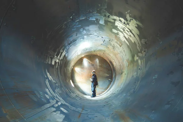 作業男性検査溶接 タンク機器トンネルの地下に閉じ込められた側面の懐中電灯を使用して ロイヤリティフリーのストック画像