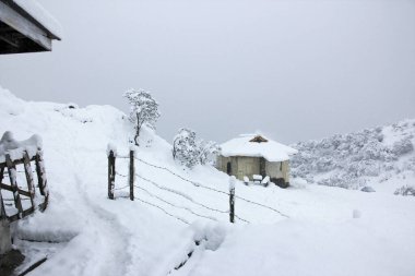 Himalayalar 'da Dağlarda Karlar Altında Küçük Ev