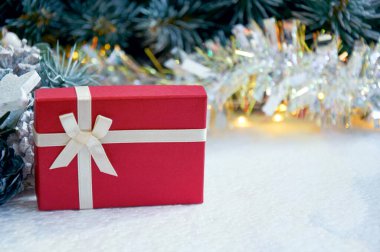 Noel kompozisyonu köknar ağacı dalları, kırmızı hediye kutusu ve altın renkli çelenk renginde gümüş süslemeler.