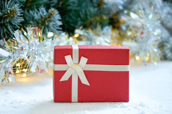 Noel kompozisyonu köknar ağacı dalları, kırmızı hediye kutusu ve altın renkli çelenk renginde gümüş süslemeler.