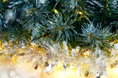 Noel ağacı dallarıyla Noel arkaplanı, altın çelenk ışığında gümüş süslemeler