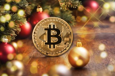 Noel ağacı ve ahşap arka planda bokeh ışıkları olan altın bitcoin.