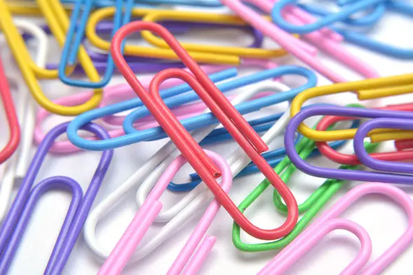 Beyaz arkaplanda renkli ataçlar