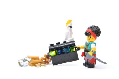 Göğsünde değerli taşlarla dolu kakadu olan küçük bir korsan kız figürü. Plastik tuğlaların editoryal illüstrasyon görüntüsü. 27. Basım.