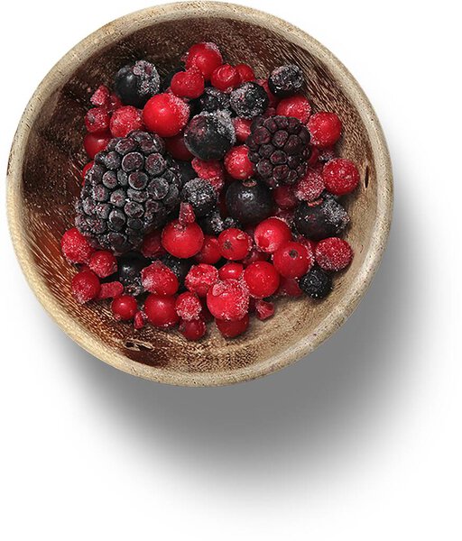 Различные замороженные ягоды на деревянной чаше.