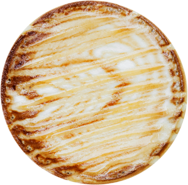 Yuvarlak bir tatlı, üzerinde altın rengi kahverengi bir kapak ve serpiştirilmiş desenler var, muhtemelen bir pasta ya da hamur işi..