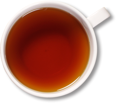 Koyu kahverengi çayla dolu bir fincanın üst görüntüsü pürüzsüz yüzeyi ve zengin rengini gözler önüne seriyor..