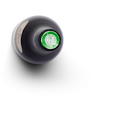 Yeşil kapaklı siyah bir şişenin üst görüntüsü, bir içecek içerdiğini gösteriyor..