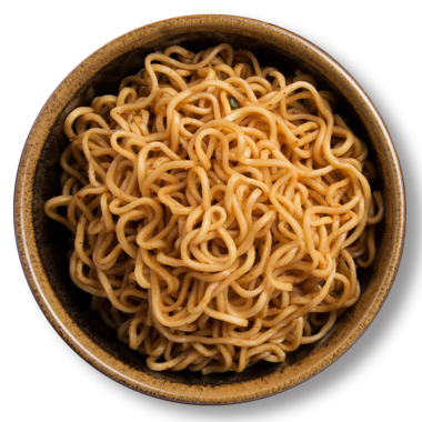 Bir kase pişmiş erişte, muhtemelen baharatlı, basit ve rahatlatıcı bir yemek seçeneği sunuyor..