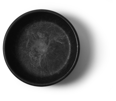 Basit bir siyah kase, pürüzsüz bir iç yüzeyi var, muhtemelen yemek servisi için ya da dekoratif bir parça olarak kullanılıyor..