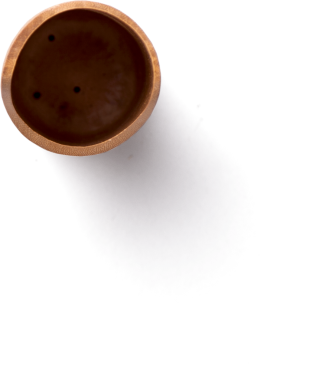 Basit, yuvarlak bir seramik kase, pürüzsüz bir yüzeyi ve üzerinde üç delik, yumuşak bir gölgesi var..