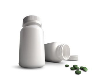 Etrafa saçılmış birkaç yeşil haplı iki beyaz şişe, sağlık ve ilaç tedavisine odaklandığını gösteriyor..