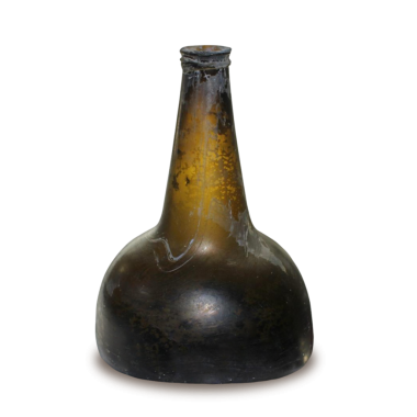 Koyu, yuvarlak bir tabanı ve dar bir boynu olan klasik bir cam şişe. Muhtemelen sıvı depolama için kullanılıyor..