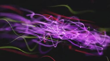 Renkli çizgilerin koyu arkaplana karşı soyut görüntülenmesi.