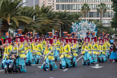 SANTA CRUZ DE TENERIFE, SPAIN - FEBRUARY 21, 2023: Around the Coso parade - along the Avenida de Anaga, official end of Carnival. Amazing warm evening, joyful people in carnival costumes have fun.